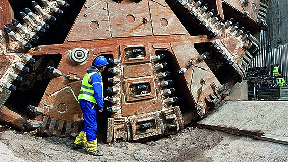 Arbeiter vor großem Tunnelbohrer